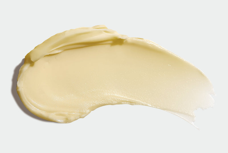 Close-up of a smooth, honey-colored Body Butter on a light gray background