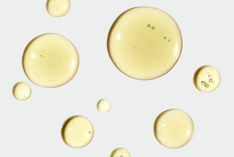 Yellow droplets of oil on a light gray background