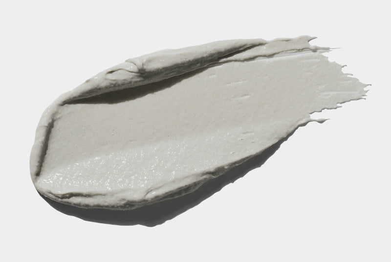 Grey-green swipe of finely ground face polish on a white background