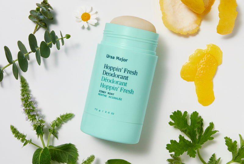Mint green Ursa Major deodorant stick on a white background with natural elements