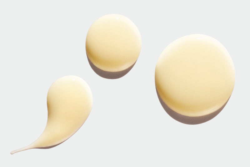 Three light beige serum droplets on a white background